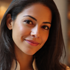 Portrait of a smiling Latina woman with dark wavy hair, warm lighting, and a soft blurred background.